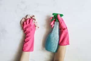 person with spray bottle wearing gloves and a towel for cleaning service Dallas Sunrise Maids Plano, TX