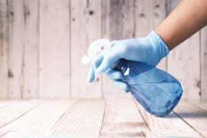 hand with glove on spraying floor for cleaning service Dallas Sunrise Maids Plano, TX