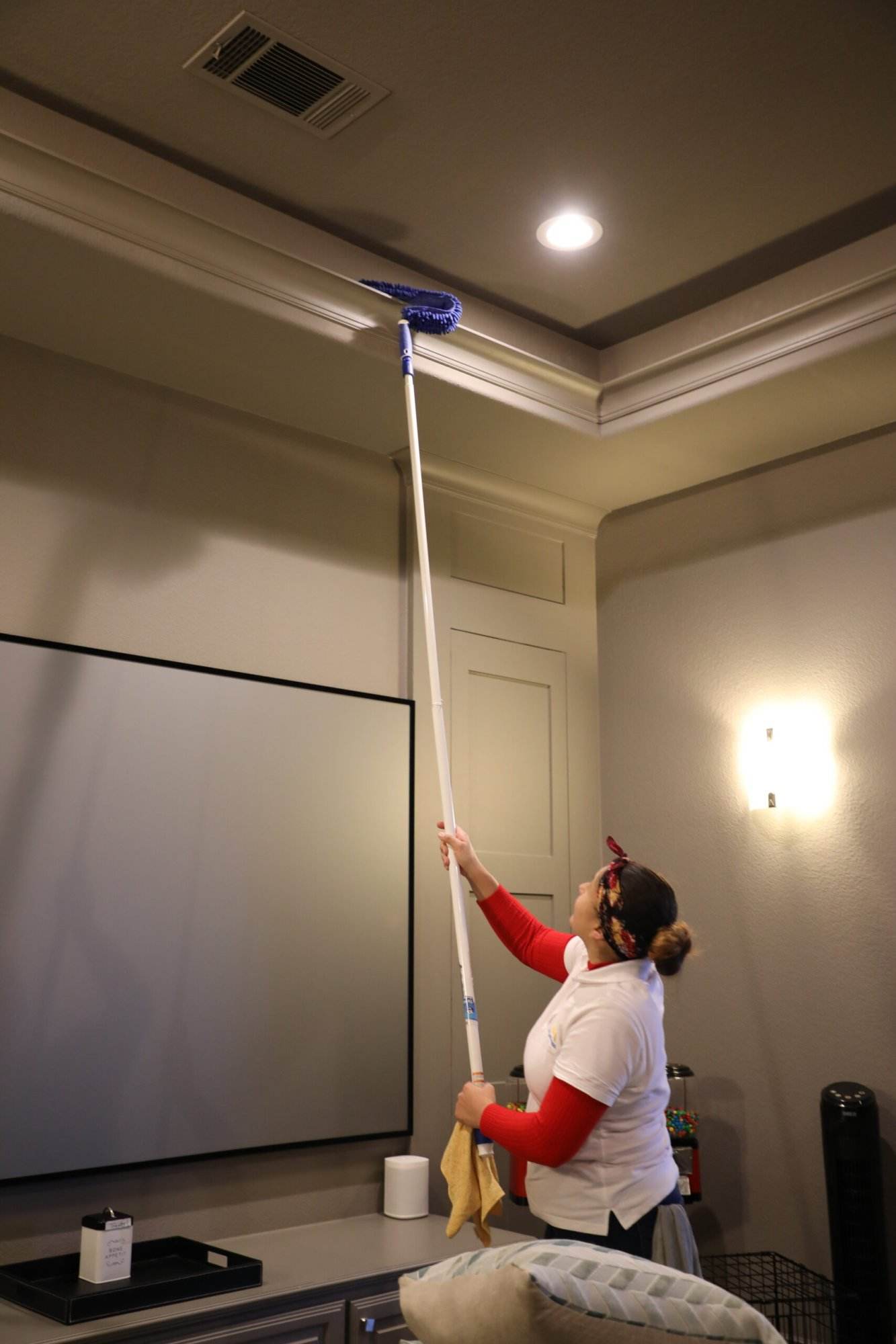female cleaner dusting with extended arm duster for high ceilings Dallas Sunrise Maids in Plano, TX