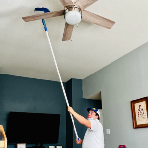 Dallas Sunrise Maids crew holding a long mop cleaning a ceiling fan in Plano, TX