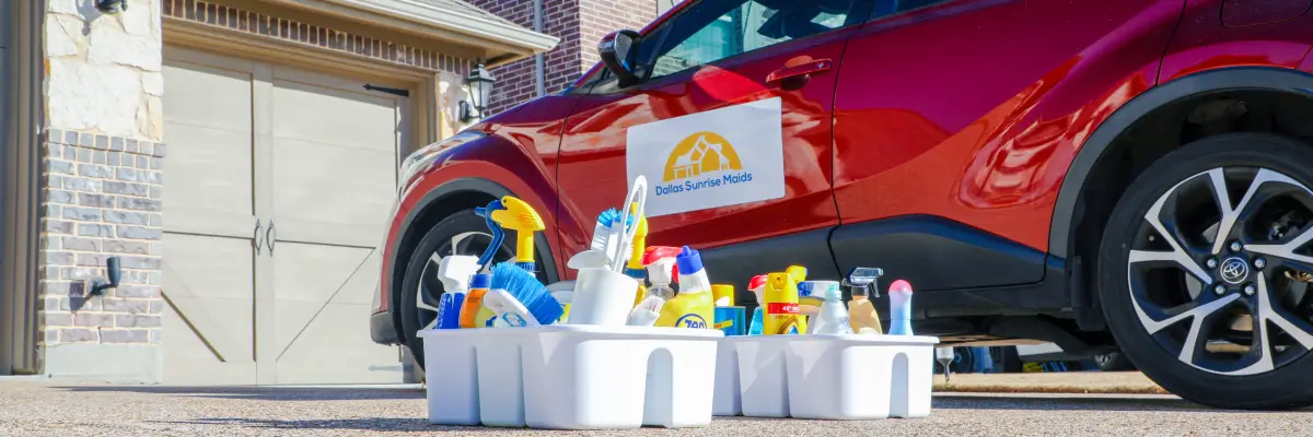 Professional house cleaning supplies organized in caddies next to Dallas Sunrise Maids service vehicle by Dallas Sunrise Maids in Plano