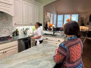 Professional cleaner wiping kitchen countertops during a home walkthrough demonstrating professional house cleaning standards in Plano, TX by Dallas Sunrise Maids