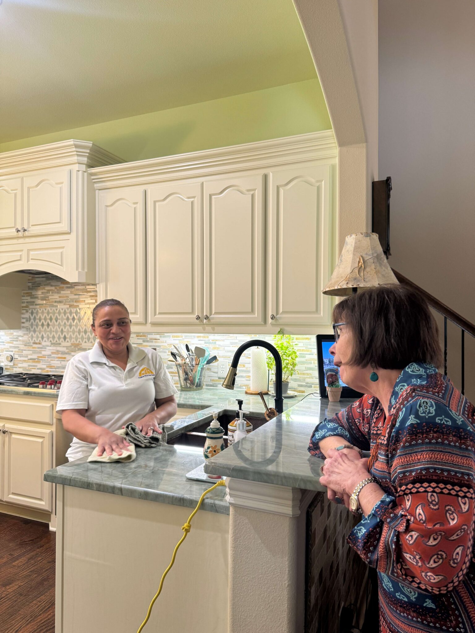 Cleaner wiping kitchen countertop professional house cleaning standards in Plano, TX by Dallas Sunrise Maids